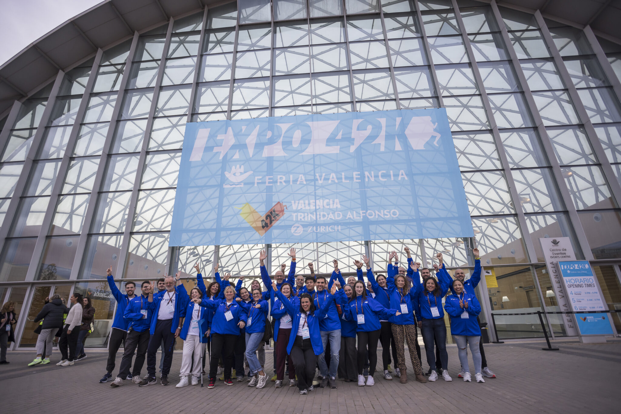 Un grupo de voluntarios y voluntarias del Maratón Valencia en la puerta de Expo 42K Feria Valencia.